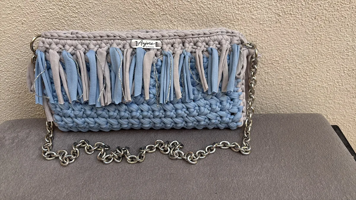 Anjore Sky fringe clutch Anjore Sky fringe clutch, handmade crochet by Atelier Annamaria. Light blue clutch with a fringe and silver chain.