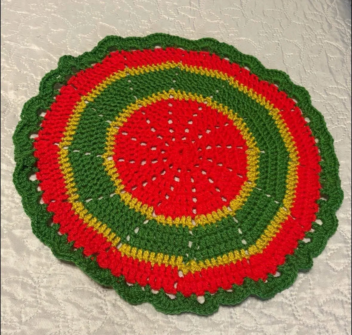 Sunrise round mat Sunrise round mat, handmade crochet by Atelier Annamaria. Red, yellow and green mat with a scalloped edge.