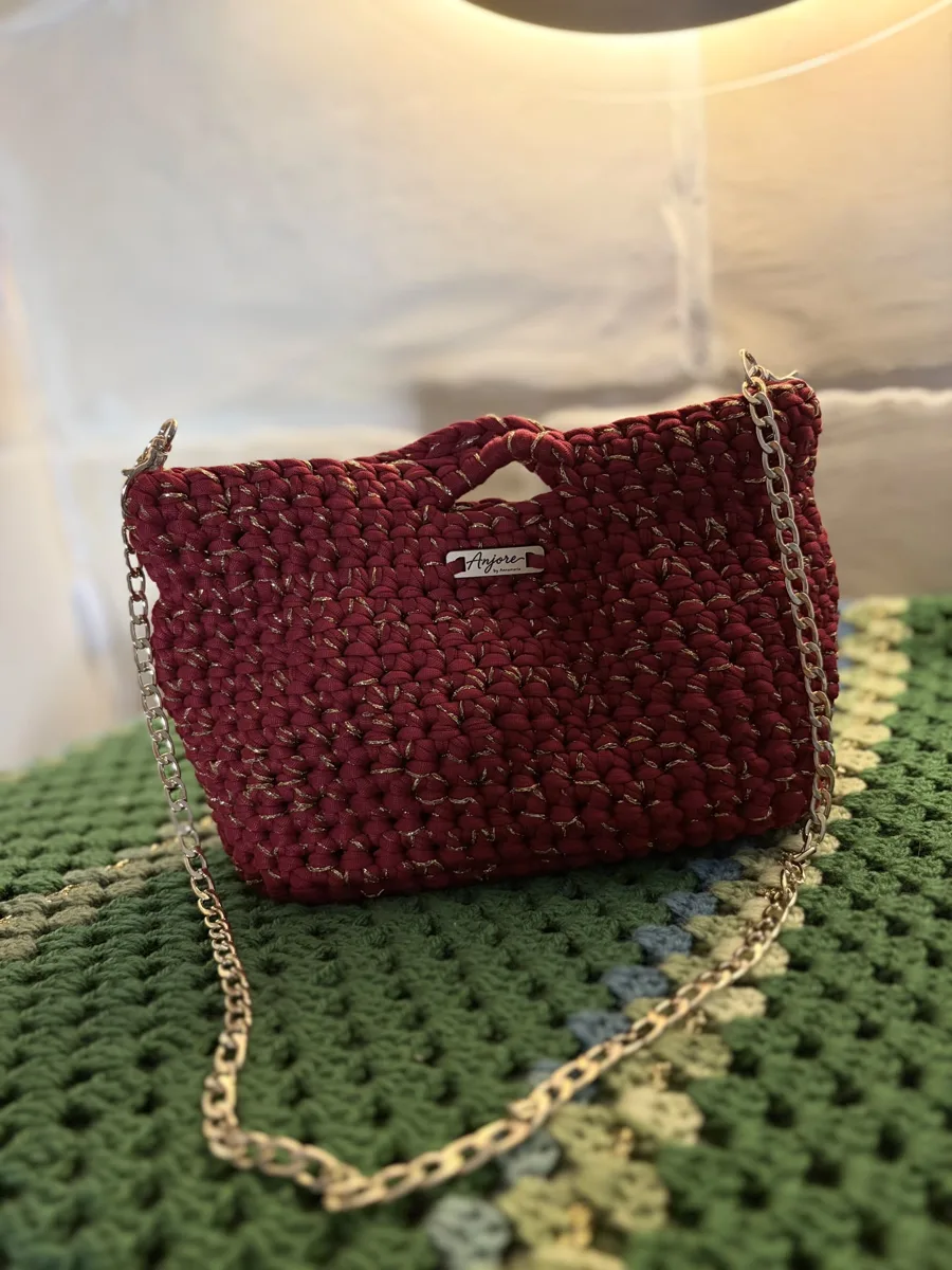 Anjore Burgundy chain bag Anjore Burgundy chain bag, handmade crochet by Atelier Annamaria. Deep red chunky bag with a gold chain.