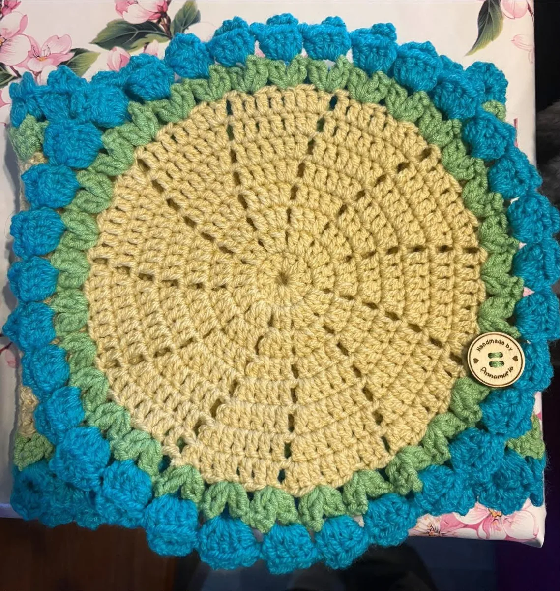 Sunflower cushion cover Sunflower cushion cover, handmade crochet by Atelier Annamaria. Yellow centre framed by green and bright blue bobble edging.