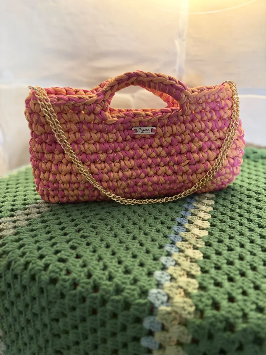Anjore Coral sunset bag Anjore Coral sunset bag, handmade crochet by Atelier Annamaria. Coral and pink chunky bag with a gold chain.