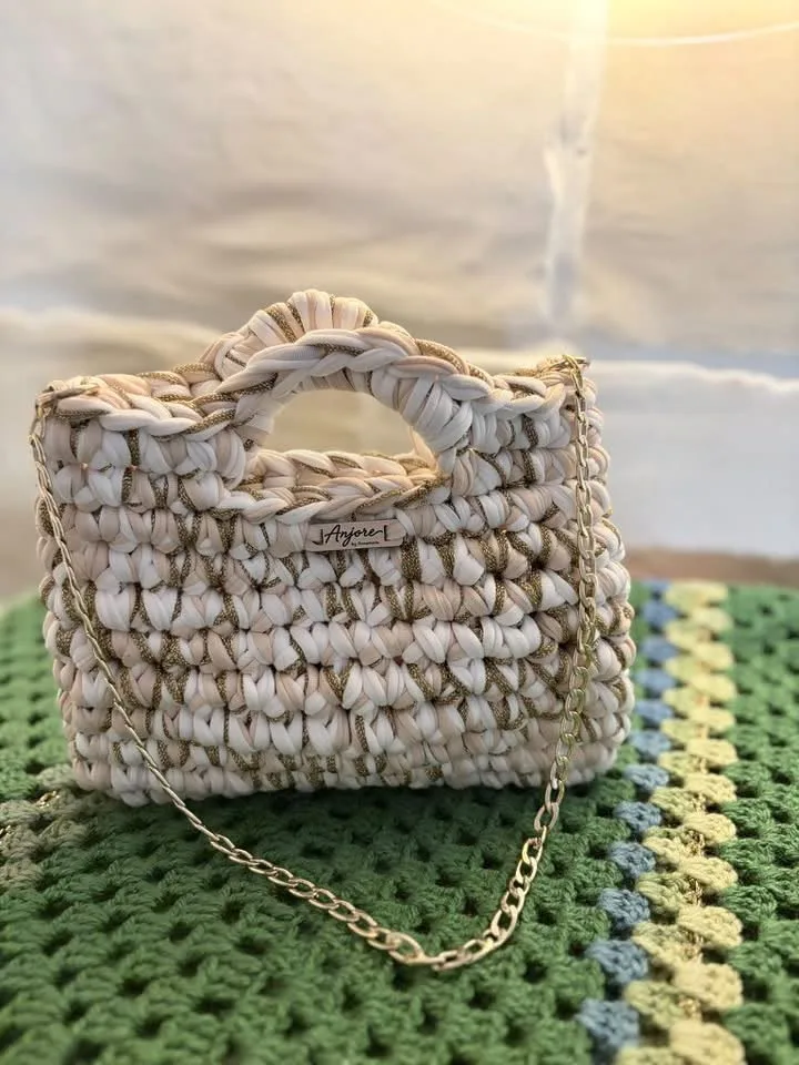 Anjore Cream and gold ruffle bag Anjore Cream and gold ruffle bag, handmade crochet by Atelier Annamaria. Cream bag with golden sparkle and ruffled handles.